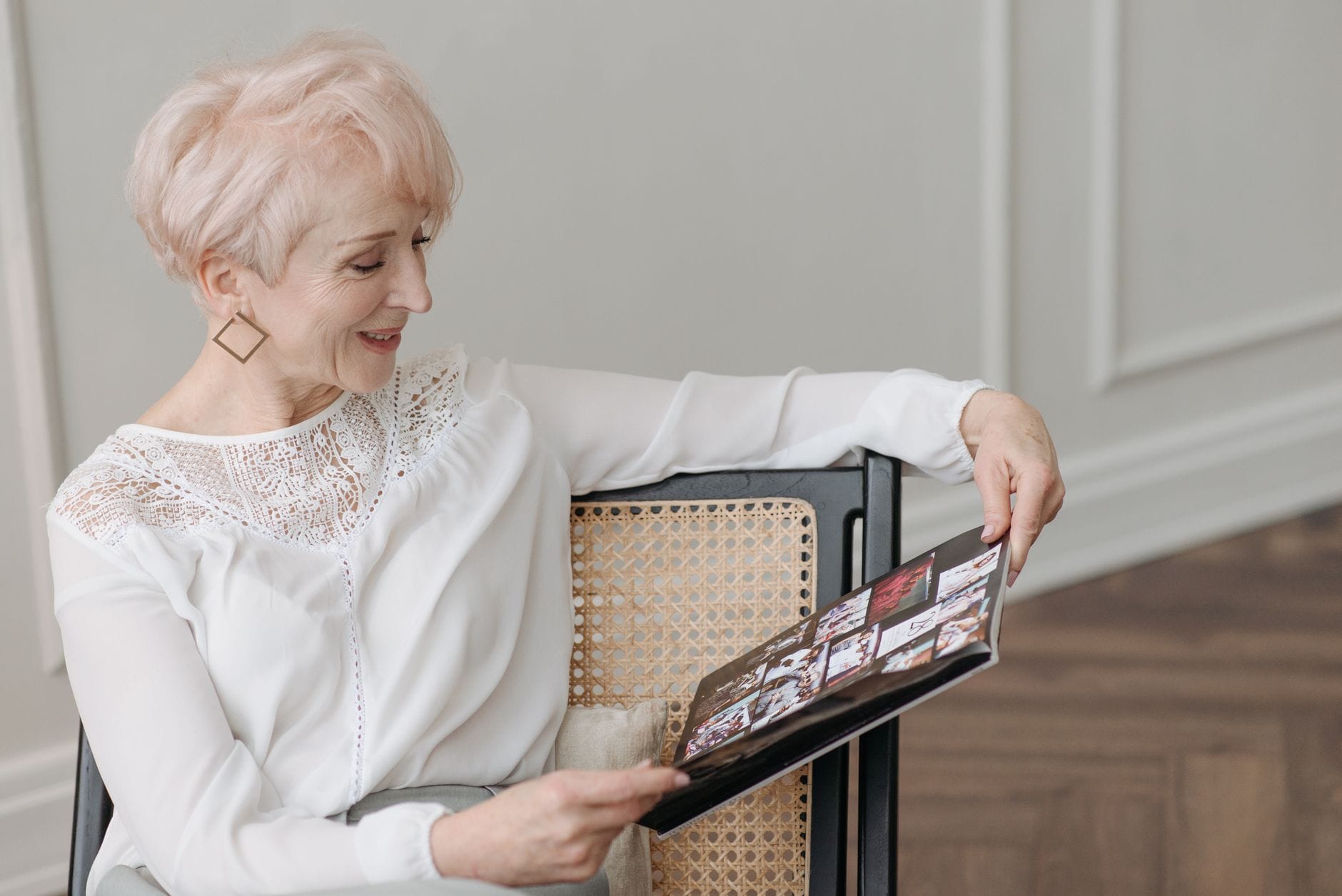 Uśmiechnięta seniorka czyta książkę w przytulnym pokoju